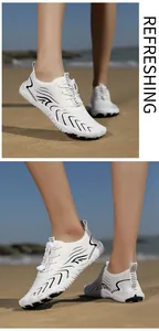 Atmungsaktive weiße Outdoor-Wasserschuhe mit schwarzen Wellenmustern an einem Sandstrand