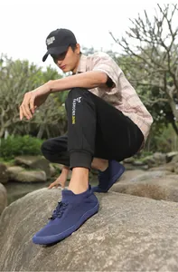 Dettaglio di scarpe da camminata traspiranti in maglia blu scuro indossate all'aperto