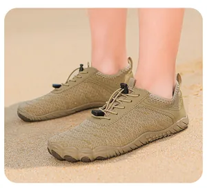 Leichte khakifarbene Wasserschuhe im Sand, ideal für Strand und Wanderungen im Freien.