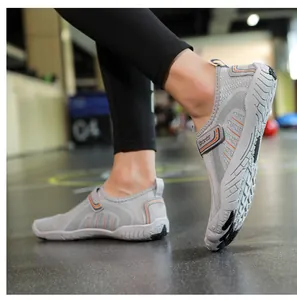Detailed side view of grey breathable river shoes with non-slip rubber soles on feet