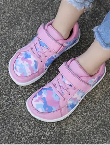Detail of pink camouflage children's breathable sneakers with velcro straps outdoors