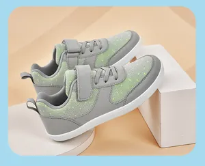 Close-up view of grey and green children's outdoor sports sneakers with velcro strap.