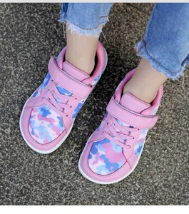 Close-up of children's pink camouflage knit sneakers with wide toe and velcro straps.