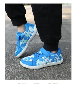 Detailed view of blue camouflage children's fly-knit sneakers with Velcro closure strap