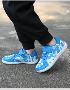 Detail view of blue camouflage pattern children's sneakers with Velcro strap and flat sole