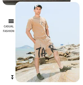 Model trägt armee-grüne Fünf-Finger-Wasserschuhe an einem steinigen Strand