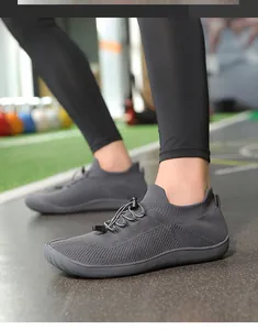 Dettaglio di scarpe a piedi nudi in maglia grigia con punta larga e lacci