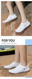 Detailed view of white breathable outdoor wading shoes worn on a beach and rocky shore