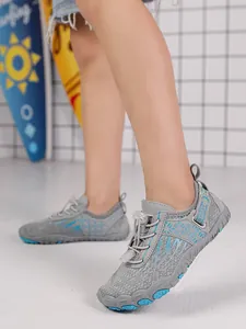 Close-up detailed side view of children's grey and blue non-slip wading shoes on model