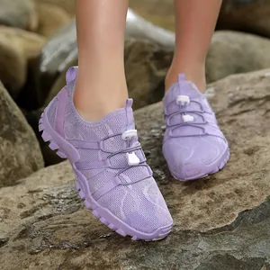 Ademende paarse outdoor wandelschoenen met antislipzolen voor dames en heren op rotsen