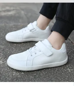 Detail of white flyknit sneakers with velcro strap and wide toe for kids
