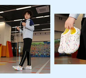 Details of kids barefoot water shoes with colorful graffiti shown in a gym setting.