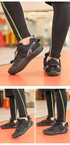 Detail view of black children's barefoot exercise shoes with flexible non-slip soles.