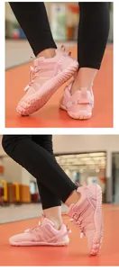 Detail showing pink children's sports shoes with non-slip soft soles for indoor exercise