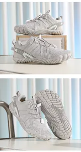 Detail view of grey kids barefoot sports shoes with textured non-slip soles.
