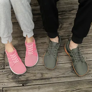 Close-up detail of wide-toe barefoot training shoes in pink and olive green mesh material