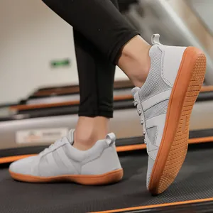 Grey minimalist wide toe box barefoot training shoes with a brown gum sole on treadmill