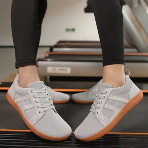 Detailed view of grey wide toe box barefoot training shoes on a treadmill