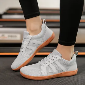 Lightweight grey wide toe box barefoot shoes shown on feet for gym training and running