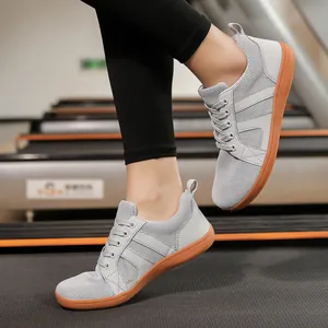 Close-up view of grey wide-toe barefoot training sneakers being used on a treadmill