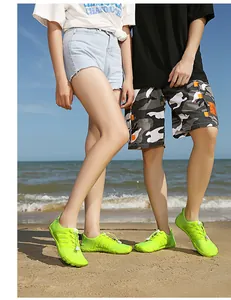 Vista dettagliata di scarpe da scoglio verde neon per coppia sulla spiaggia