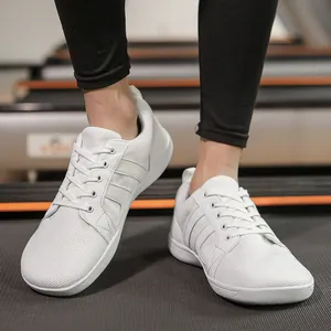 White wide-toe barefoot training shoes for fitness and indoor running on a treadmill.