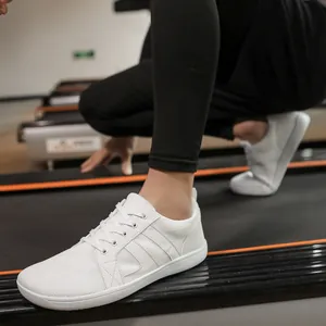 Close-up of white wide-toe barefoot training shoes for fitness and running sessions