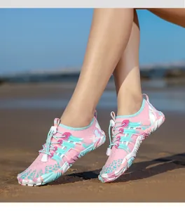 Primo piano di scarpe da scoglio rosa ad asciugatura rapida su una spiaggia sabbiosa