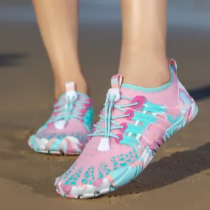 Primo piano di scarpe da scoglio ad asciugatura rapida rosa e ciano sulla spiaggia