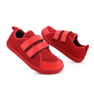 Dettaglio ravvicinato di sneakers sportive rosse traspiranti per bambini con doppio velcro