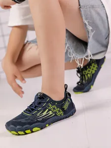 Side view detail of a child's navy blue and neon green quick-dry water shoes for sport