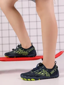 Detailed view of kids non-slip water shoes with vibrant neon green wing patterns
