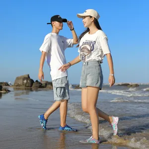 Coppia asiatica indossa scarpe da scoglio ad asciugatura rapida sulla spiaggia