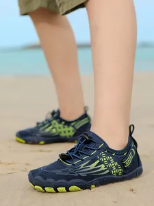 Detailed view of children's navy and lime green anti-slip water shoes on sand