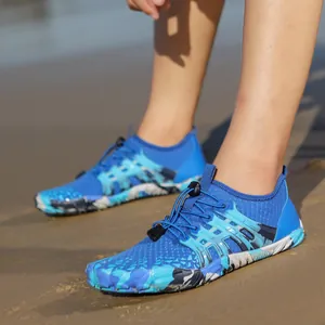 Dettaglio di scarpe da scoglio traspiranti con suola mimetica sulla sabbia marina