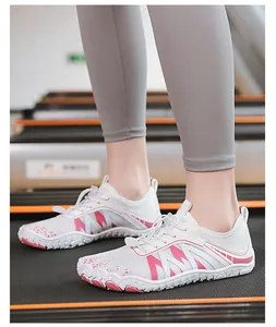 Scarpe da corsa minimaliste a piedi nudi bianche e rosa su un tapis roulant