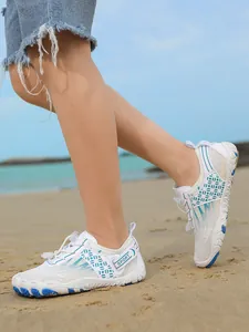 Detail view of children's breathable non-slip water shoes on a sunny sandy beach