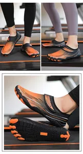 Dettaglio della suola in gomma antiscivolo e design a 5 dita delle scarpe arancio