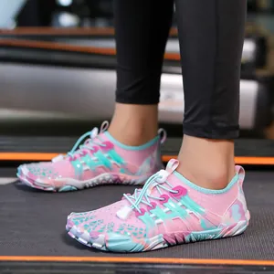 Primo piano di scarpe da scoglio a rapida asciugatura rosa e blu su un tapis roulant.