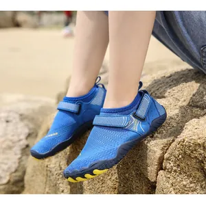 Primo piano di scarpe da scoglio blu per bambini con cinturini regolabili sulla spiaggia
