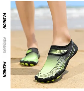 Vista dettagliata delle scarpe da scoglio verdi a cinque dita sulla spiaggia