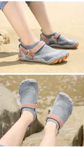 Vista dettagliata di scarpe da scoglio grigie per bambini sulla spiaggia con accenti arancio