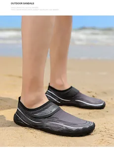 Primo piano di scarpe da acqua grigie ad asciugatura rapida indossate sulla spiaggia