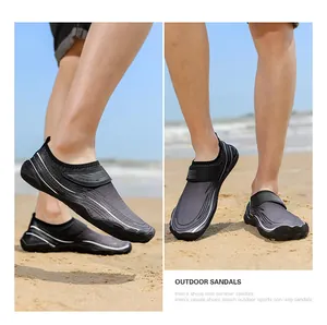 Dettaglio di scarpe da scoglio antiscivolo da uomo su una spiaggia con onde del mare