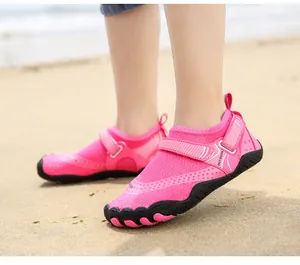 Primo piano di scarpe da acqua rosa per bambini con cinturini in velcro sulla spiaggia