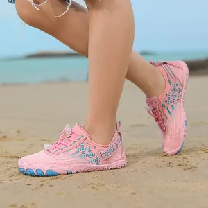 Pink non-slip water shoes for kids on a sandy beach for swimming and wading