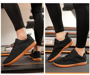 Detailed view of breathable black barefoot running shoes with wide toe box on a treadmill