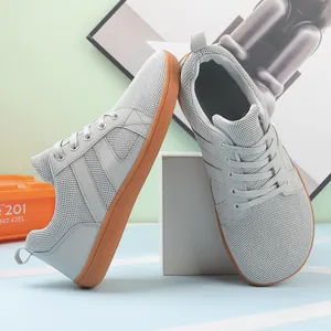 Detailed macro shot of grey wide toe box barefoot training shoes with gum rubber soles.