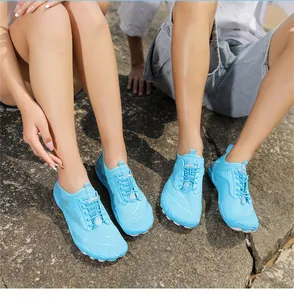 Primo piano di scarpe da scoglio blu traspiranti indossate per escursioni all'aperto su rocce.