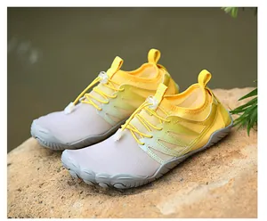 Detailed view of yellow gradient quick-dry water shoes on a natural rock